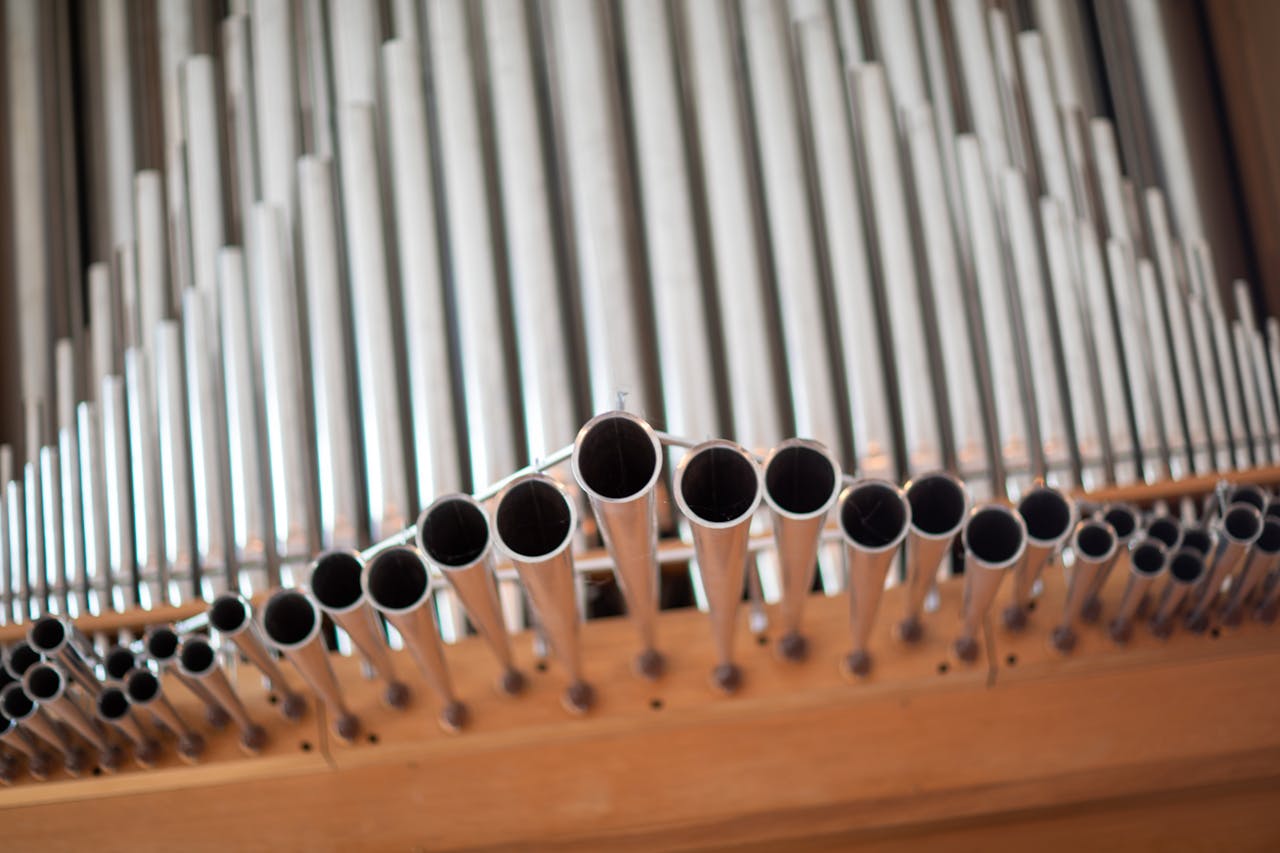 Detailed close-up shot of silver pipe organ tubes with selective focus, a stunning instrument view.